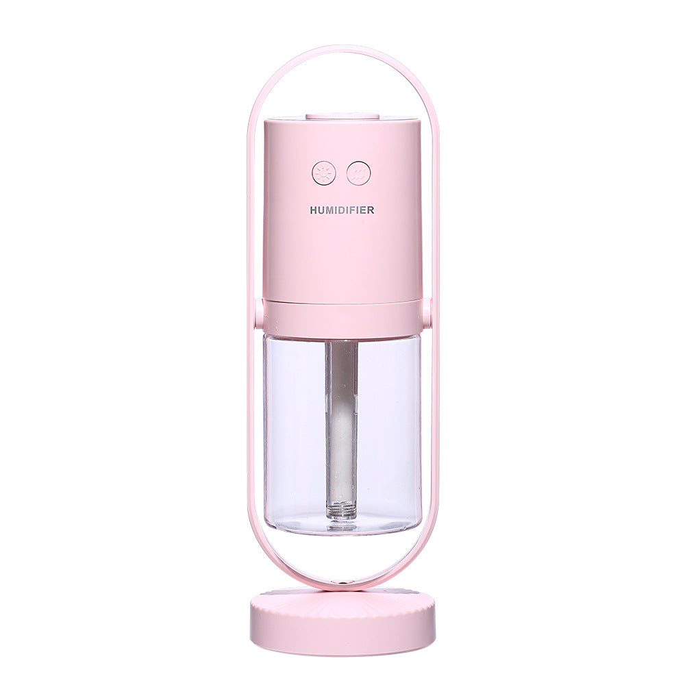 Pink unit, plain white background — Pink portable USB humidifier with clear water tank, front view