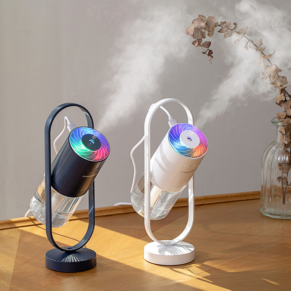 plant) Two portable USB humidifiers with ambient color light producing mist on a wooden table