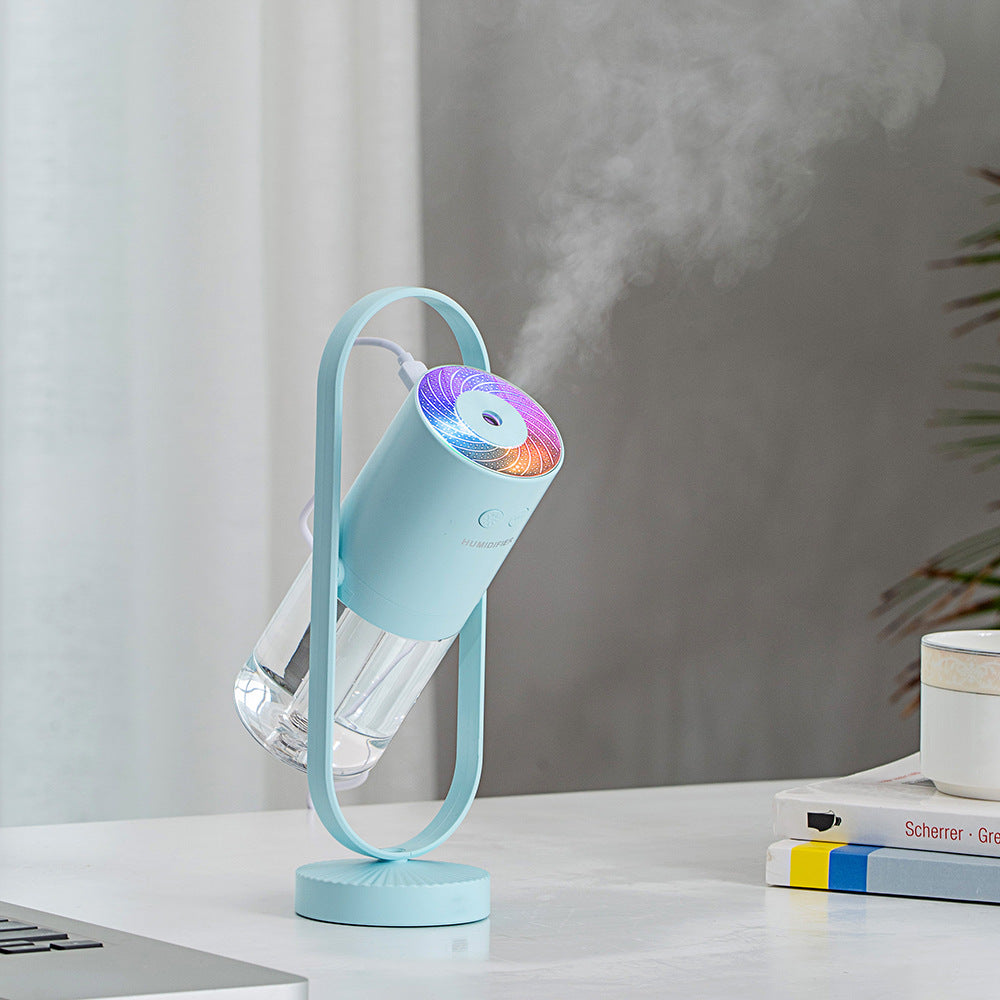 Light blue USB humidifier producing fine mist with glowing top light