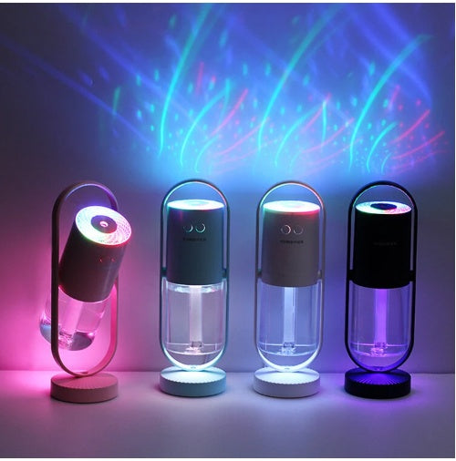 Four units glowing (pink/teal/purple/blue) — Four color USB humidifiers glowing with ambient light in dark room